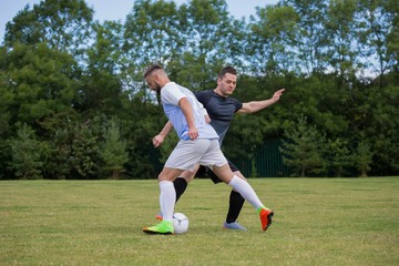 Football players playing soccer in the ground