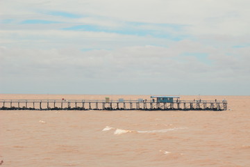 Bridge over The Brown Río de la Plata in Argentina, Buenos Aires with a small blue house and blue sky
