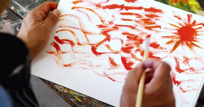 Overhead of artist painting on canvas 
