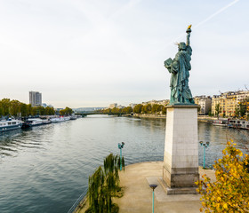Fototapeta premium The replica of the Statue of Liberty in Paris, France, located at the southern tip of the Ile aux Cygnes, overlooking the river Seine.
