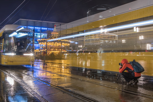 Photographer is between two trams to photograph a approaching tram. Long Exposure