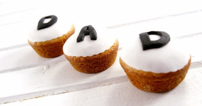 Muffins with text dad arranged on wooden plank 