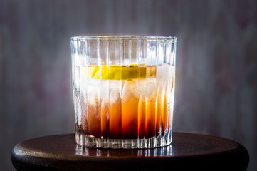Glass of whiskey, lemon with ice.