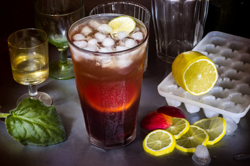 Big fruit cocktail at a party, glasses, lemon and ice