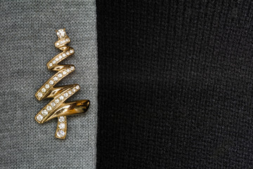 A gold broach with diamonds on a sweater background.