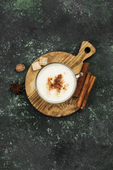 Christmas drink eggnog and ingredients on a green background. Top view