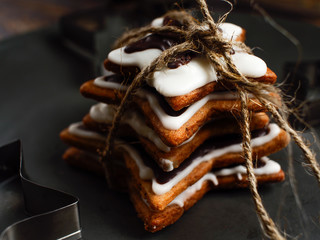 The recipe for making ginger biscuits. Ginger cookies in the form of a star tied up by a cord on a gray plate..