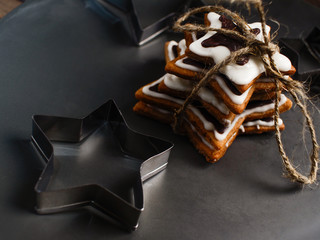 The recipe for making ginger biscuits. Ginger cookies in the form of a star tied up by a cord on a gray plate..