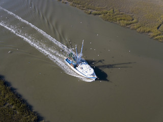 Naklejka premium Aerial view of commerical fishing vessel coming into port.