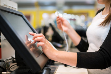 Young woman hand doing process payment on a touchscreen cash register, finance concept