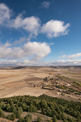 Fototapeta na wymiar Countryside landscape in Burgos province, Castilla y Leon, Spain. Castrojeriz village is in the foreground, a blue sky and clouds over the agricultural fields.
