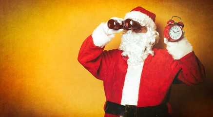 Santa Claus holding binoculars and alarm clock