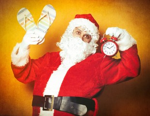 Santa Claus holding flip flops and alarm clock