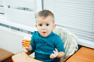 baby in the kitchen eagerly eating the delicious cream horns, vanilla cream