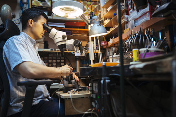 Jeweler working with optical device