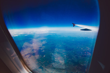 Fototapeta na wymiar Looking through window aircraft during flight in wing blue sky.