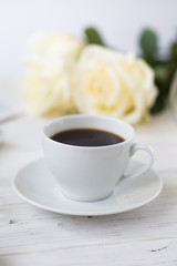 Coffee for breakfast or lunch with decorations, candles and flowers. white roses on the table and cup of coffee