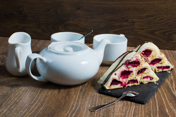 a teapot and a couple of cups with a cake on the table