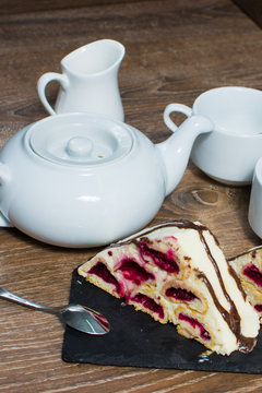 a teapot and a couple of cups with a cake on the table