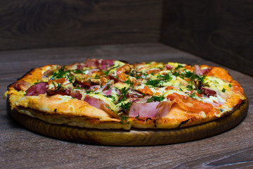 pizza with ham and cheese on a board