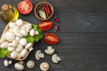 mushrooms with tomatoes, parsley, oil, garlic, chili pepper, peppercorns on dark wooden background. top view