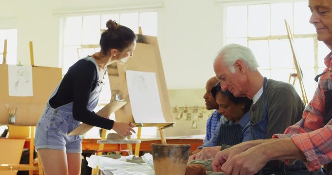 Woman assisting artists in pottery 