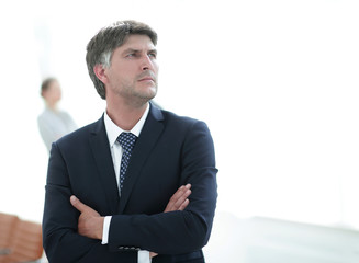 confident businessman stands and looks away.