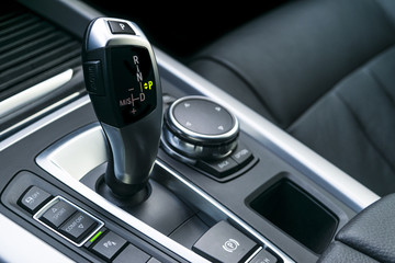 Automatic gear stick (transmission) of a modern car, multimedia and navigation control buttons. Car...