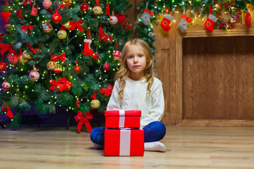 Happy little smiling girl with christmas gift box.