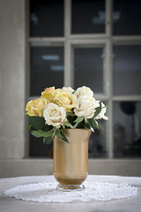 the Bouquet of artificial roses on a table in a vase, as an interior decoration