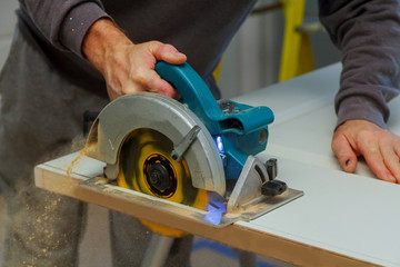 Closeup process of carpenter worker with circular saw