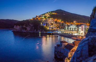 Fototapeta premium View on illuminated coastline and old town at night in Budva, Montenegro