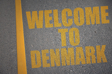 asphalt road with text welcome to denmark near yellow line.