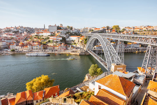 Landscape view the beautiful old town with famous iron bridge above the Douro river during the sunset in Porto city, Portugal