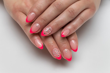 French pink manicure on long sharp nails with crystals on nameless fingers