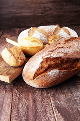 bakery concept with bread and bread rolls on wooden background.