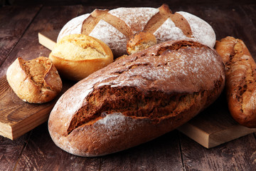 bakery concept with bread and bread rolls on wooden background.
