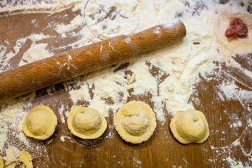 Preparation of dumplings at home in the kitchen for a family dinner in Russia Preparing, cooking, making homemade ravioli, pelmeni or dumplings with meat