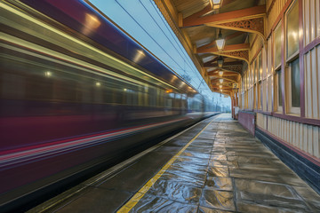 Fototapeta na wymiar Express train passing through a Victorian station at speed