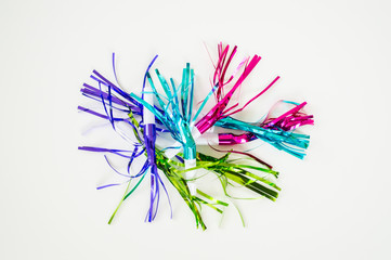 The morning after-pile of colorful New Years Eve noisemakers and streamers isolated on a solid background