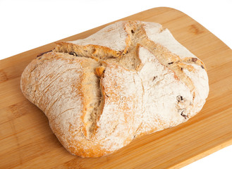 Bread, ciabata with dried tomatoes and olives, on a board, isolated on white background