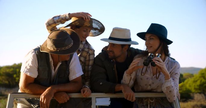 Friends looking through binoculars during safari vacation 