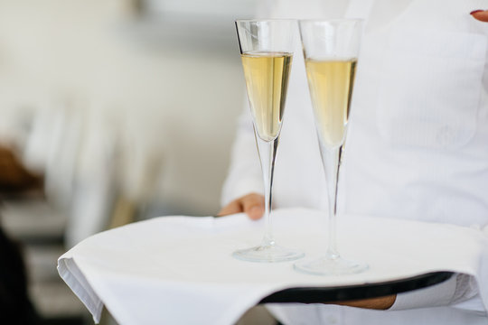Waitress holding a dish of champagne and wine glasses at some festive event, party or wedding reception