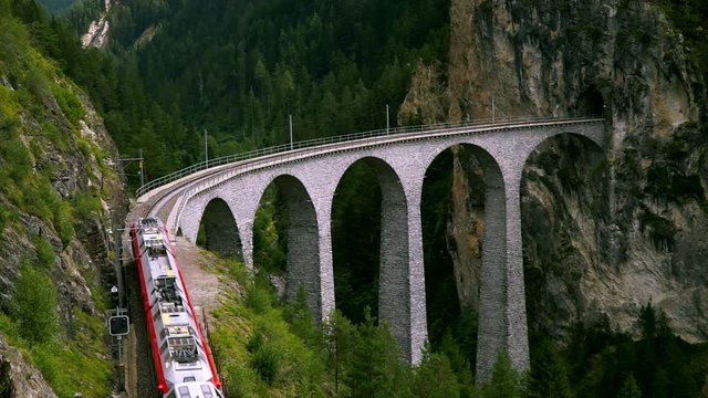 The train passes through the famous Landwasser viaduct in Switzerland. Top view.