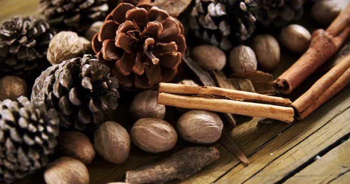 Pine cones and cinnamon sticks on wooden table 