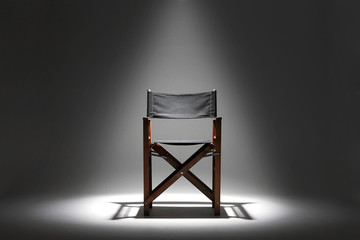 Directors chair against a plain background under a spotlight
