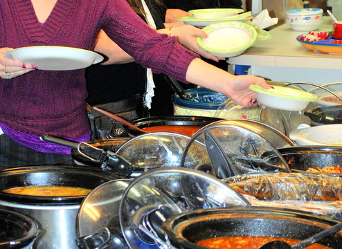 Pasta potluck dinner served inside a kitchen hall.