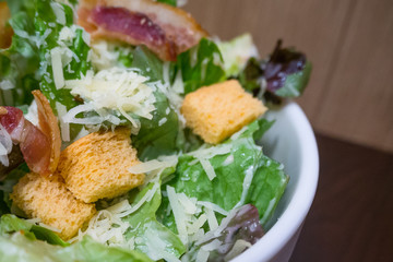 The Caesar salad in white bowl image close up.