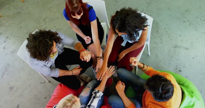 Artists forming huddle in drawing class 