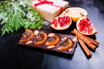 Chocolate, lemon, pomegranate and cinnamon on black backdround